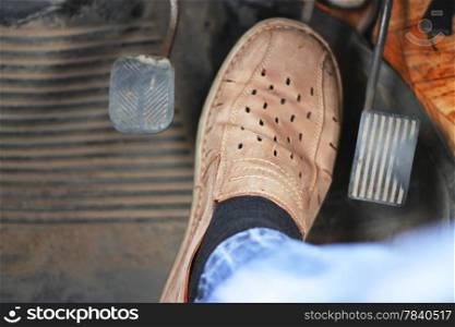 Mans feet pushing on the accelerator of automobile