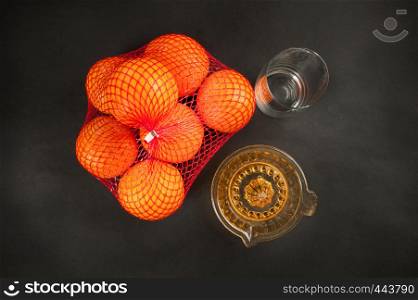 manual juicer with oranges on dark background