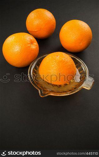 manual juicer with oranges on dark background