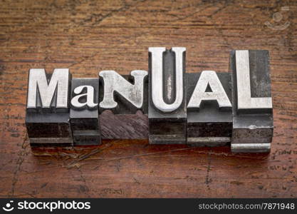 manual word in mixed vintage metal type printing blocks over grunge wood