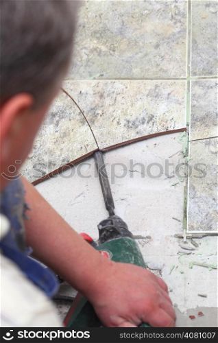 manual worker disassembling old floor tiles