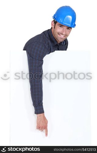 Manual worker pointing downwards at poster