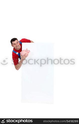 Manual worker stood with piggy-bank and blank poster