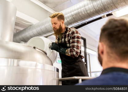 manufacture, business and people concept - men working at craft brewery or beer plant. men working at craft brewery or beer plant. men working at craft brewery or beer plant