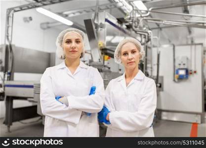 manufacture, industry and people concept - happy women technologists at ice cream factory shop. happy women technologists at ice cream factory