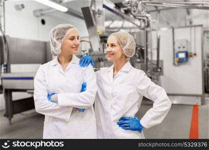 manufacture, industry and people concept - happy women technologists at ice cream factory shop. happy women technologists at ice cream factory