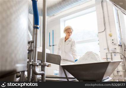 manufacture, industry, food production and people concept - woman working at ice cream factory conveyor with powdered milk. woman working at ice cream factory conveyor