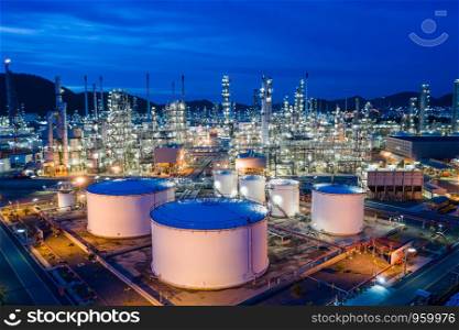 manufacturing and storage facilities oil and gas refineries products for sales and export international shipping frighted transportation open sea aerial view at night over lighting with blue sky background