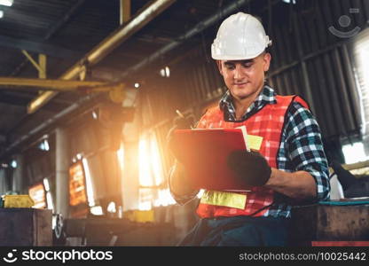 Manufacturing worker working with clipboard to do job procedure checklist . Factory production line occupation quality control concept .