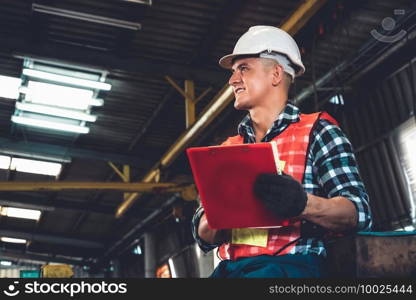 Manufacturing worker working with clipboard to do job procedure checklist . Factory production line occupation quality control concept .