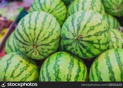 Many big sweet green watermelons and one cut watermelon
