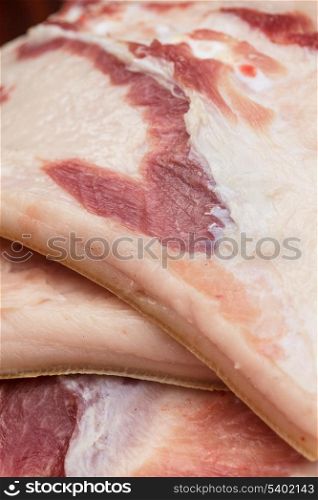 Many big uncooked pieces of lard (bacon) closeup