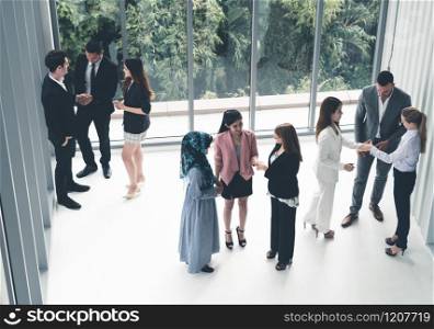 Many business people gathering in modern office building for business conference in the city. Businessmen and businesswomen communication and human resources concept.. Many business people gathering in office building.