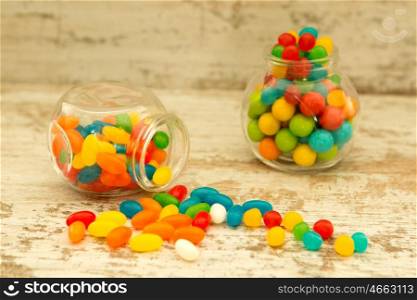 Many candy in glass with differents colors on wooden background