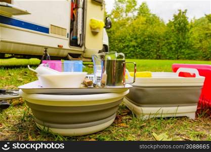 Many clean dishes drying outdoor against camper vehicle. Washing up on fresh air. Camping on nature, dishwashing outside.. Clean dishes drying on fresh air, camping outdoor