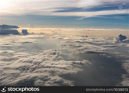Many cloud in Flying above sunrise, view from outside airplane