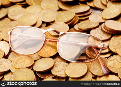 Many coins and reading glasses as business concept