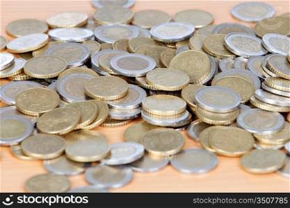 Many coins on wooden surface _shallow depth of field_