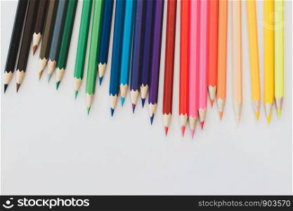 Many colored pencils, many colors on a white table
