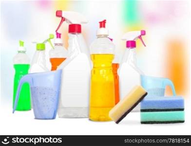 Many colorful bottles of cleaning products and spounges