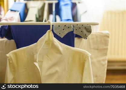 Many colorful clothing on drying rack clothes horse after laundry. Clean home interior concept.. Clothes on clothes horse