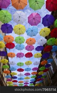many colorful hanged umbrella against blue sky