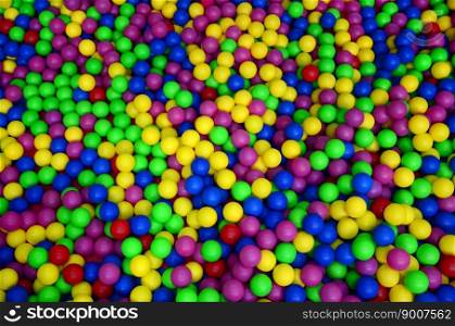 Many colorful plastic balls in a kids&rsquo; ballpit at a playground. Close up pattern