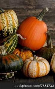 Many colorful pumpkins on rustic wooden background , autumn harvest, Halloween or Thanksgiving concept. Many colorful pumpkins