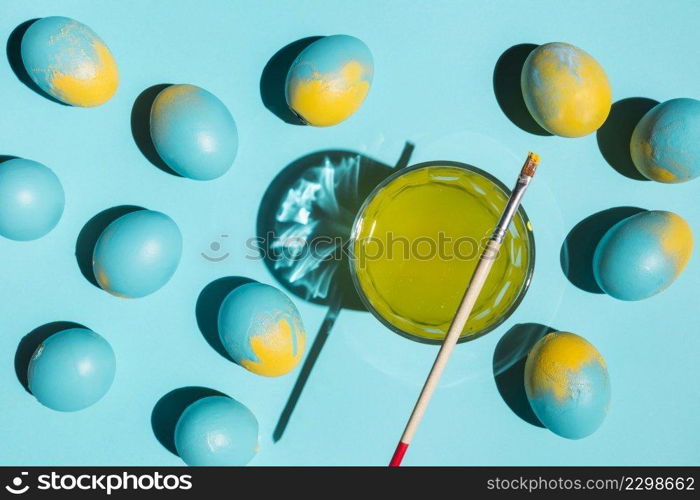 many colourful easter eggs with paint brush glass water