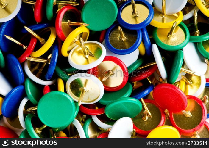 Many colourful office pins on the background