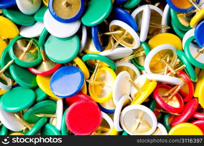 Many colourful office pins on the background