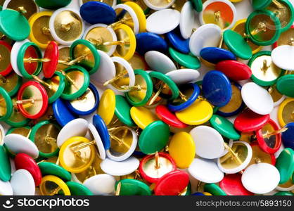 Many colourful office pins on the background