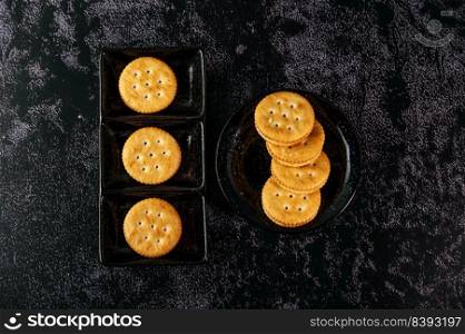 Many cookies are beautifully arranged in a plate and then placed on a wooden table. Top view