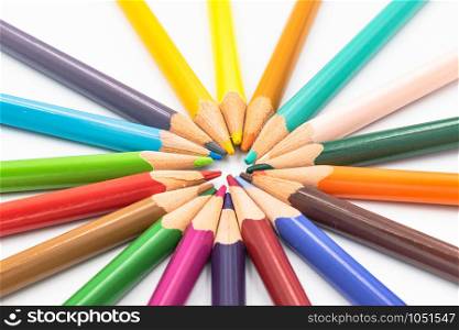 Many different color pencils lying isolated on white background in a circle