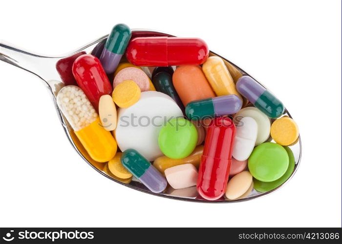many different colored pills on a spoon. abuse of drugs. isolated on white background.
