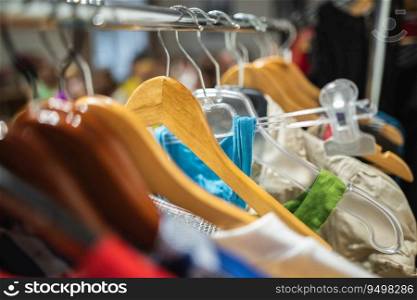 Many different colored women’s clothes on hangers in a store
