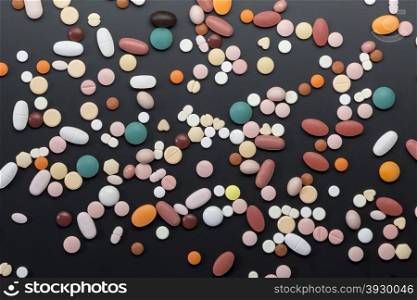 Many different colorfull pills on black background. Different colorfull pills on black