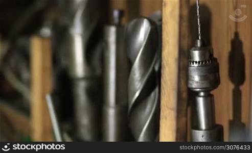 Many different old tools hanging on wall in workshop. Closeup view .