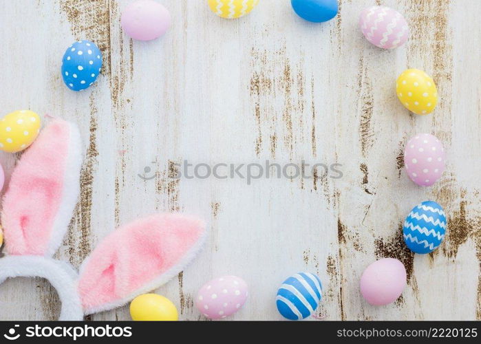 many easter eggs with bunny ears wooden table