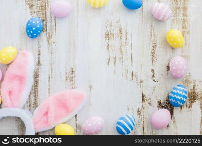 many easter eggs with bunny ears wooden table