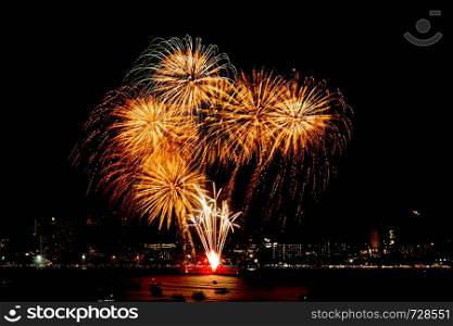 Many flashing fireworks with night cityscape background celebrate New Year.