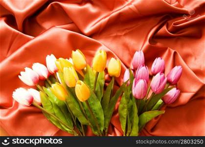 Many flowers on the red satin background