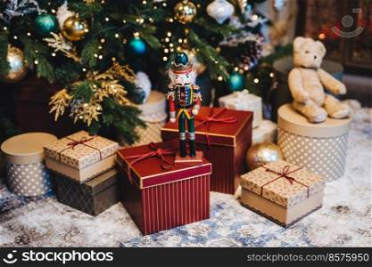 Many gifts under decorated New Year tree. Home interior and festive atmosphere. Winter holidays concept. Horizontal picture with many wrapped gifts. Calm atmosphere and festive event.