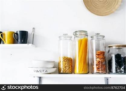 Many glass jars with dry food on kitchen shelves. Zero waste and plastic free concept. Zero waste kitchenware in cosy kitchen