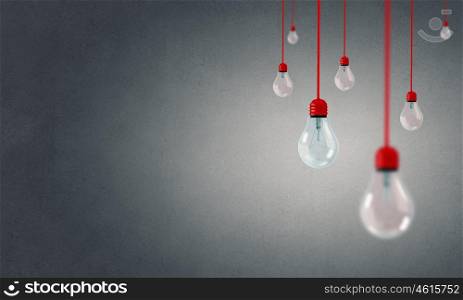 Many glass light bulbs hanging from above. Hanging bulbs