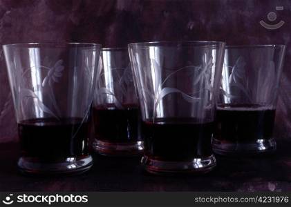 Many glasses of red wine on painted background