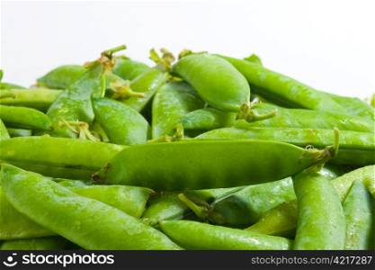Many green beans on pile, white background.