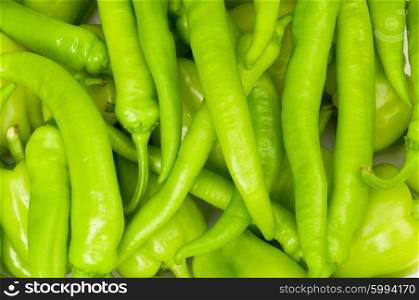 Many green hot peppers arranged at the market