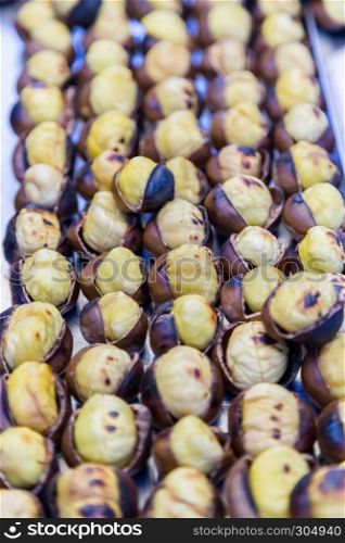 Many Grilled,roasted chestnuts for sale on a stall. Many Grilled, roasted chestnuts for sale