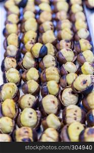 Many Grilled,roasted chestnuts for sale on a stall. Many Grilled, roasted chestnuts for sale